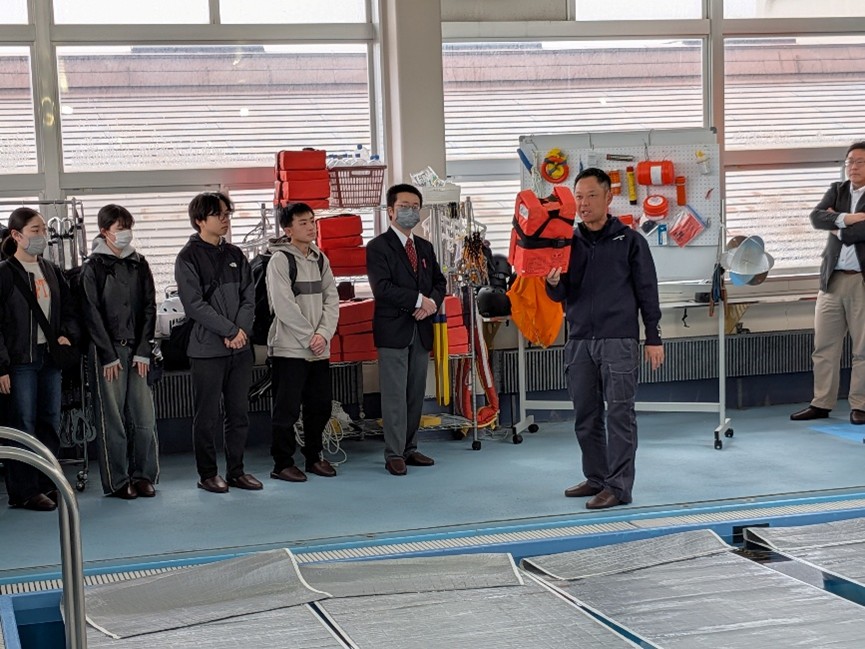 洋上サバイバル装備の説明の様子（訓練用プールで撮影）